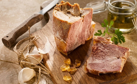 Généreux morceaux d'Anchaud de porc confit dans la graisse d'oie disposé sur planche en bois