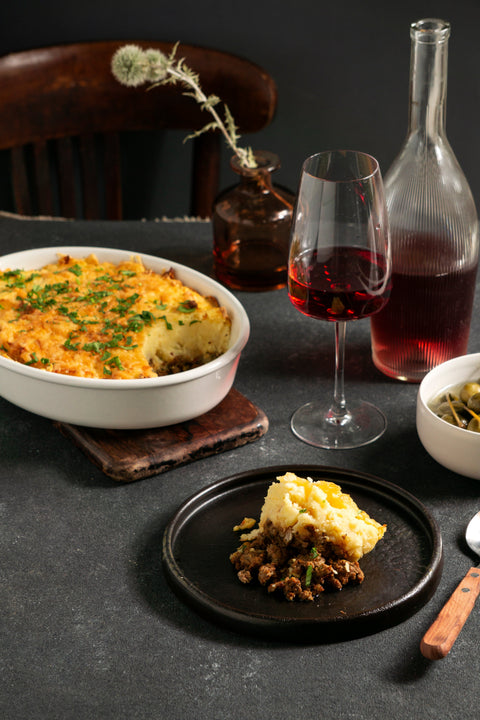 Parmentier de Canard confit entamé avec deux verres de vin rouge