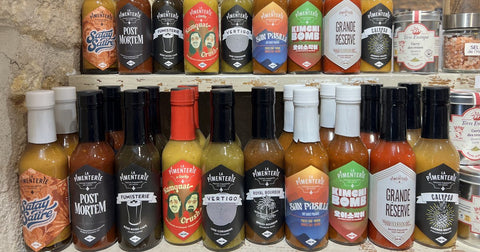 Sauces piquantes La Pimenterie sur les étagères en pierre de notre boutique de Domme